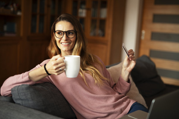 年轻女子在家里用信用卡和笔记本电脑。图片下载