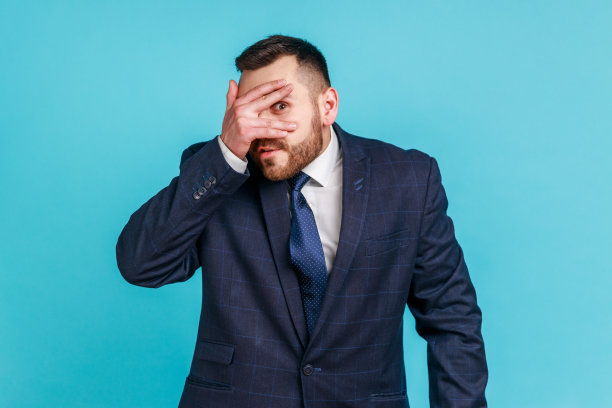 留胡子的帅气男人穿正装透过指缝偷看图片下载