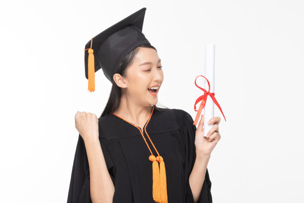 美丽迷人的亚洲女子毕业，戴着帽子和长袍，微笑着，手里拿着证书，感到如此自豪和幸福，孤立在白色的背景上，教育成功的概念图片下载