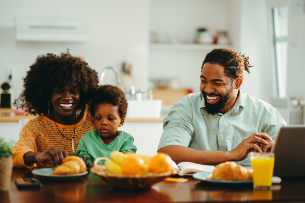 一个多元文化的幸福家庭在家里的早餐桌上。图片下载