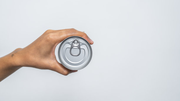手拿罐头食品孤立在白色，女人的手。图片下载
