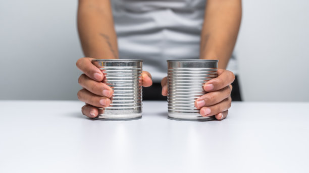 手拿罐头食品孤立在白色，女人的手。图片下载