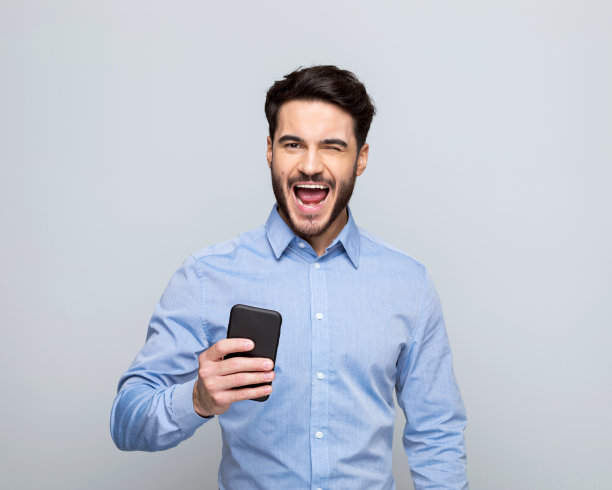 兴奋的年轻商人使用智能手机图片下载