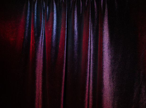 剧院的窗帘在昏暗的灯光下作为背景图片下载