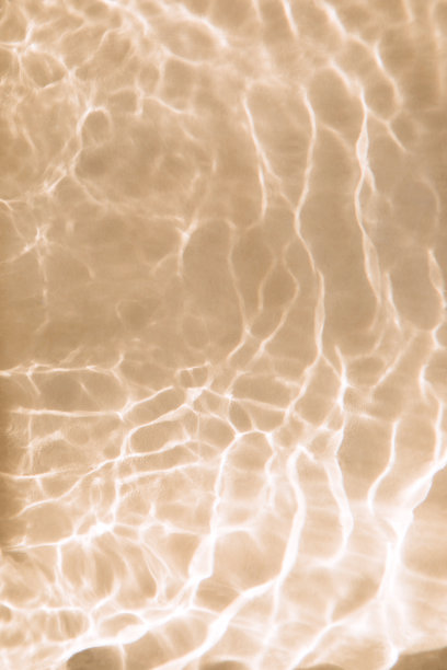 抽象的自然纹理背景，水波与太阳反射。清澈的水与泡沫和圆圈在米色背景图片下载