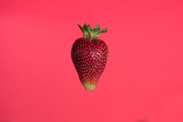 悬浮草莓在红色的背景图片下载