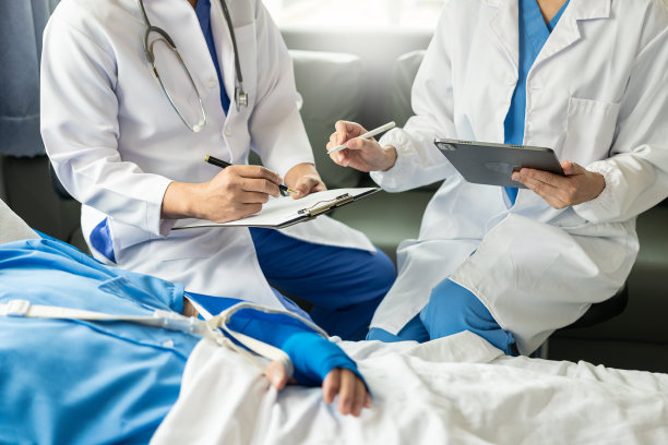 两位医生在医院接受生理盐水时与躺在床上的病人交谈专业的医疗服务理念细心的医生安慰病人库存图片图片下载