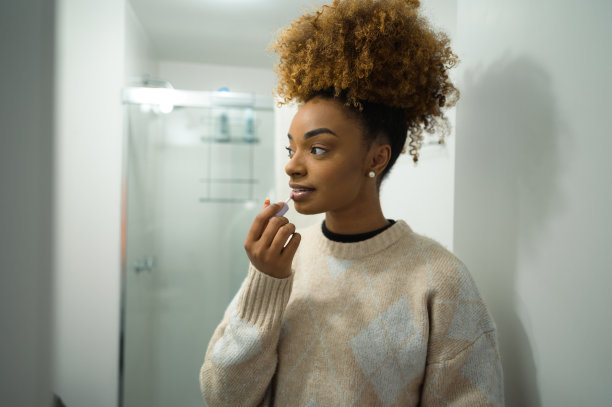 一个女人在镜子前化妆图片下载