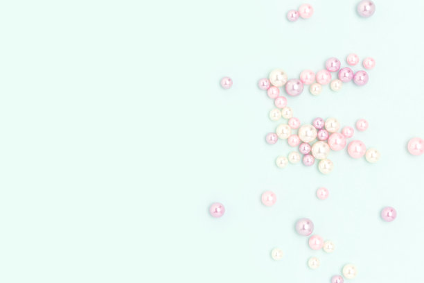 蓝色背景上散布着五颜六色的仿珍珠珠。图片下载