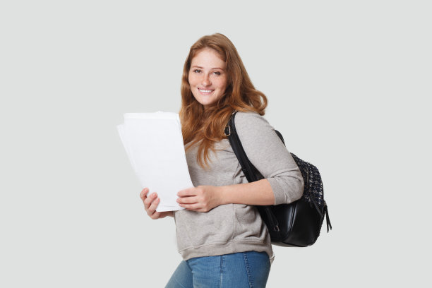 聪明的休闲女学生与背包在白色的工作室墙壁背景图片下载