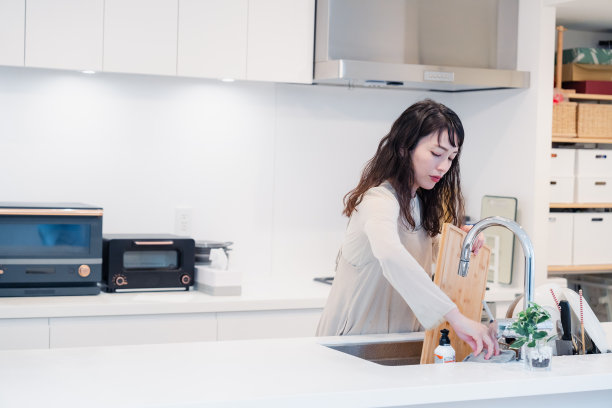 一个家庭主妇在厨房里洗盘子图片下载