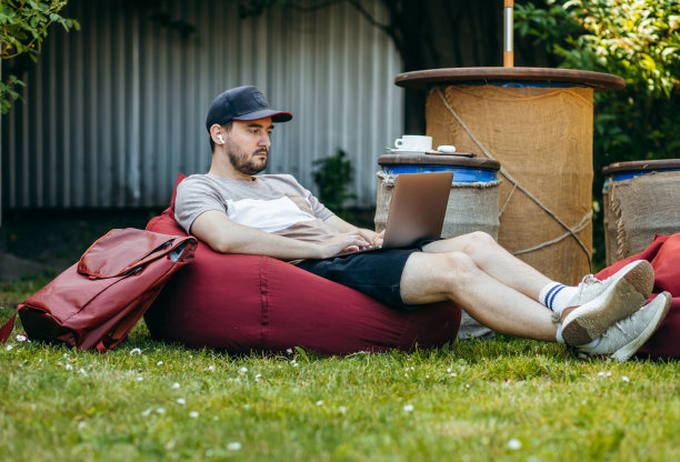 随便的成年男子在户外用笔记本电脑工作图片下载