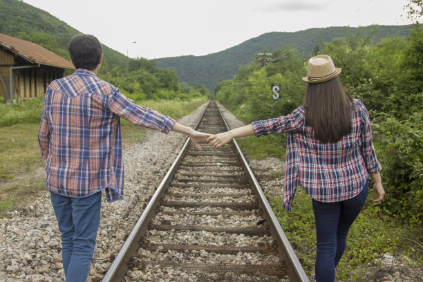 一对年轻夫妇在火车上手拉手图片下载