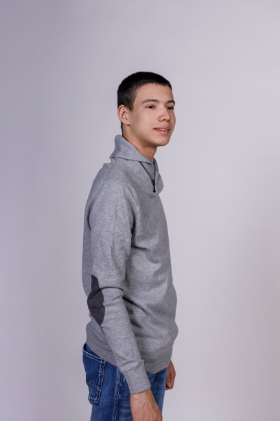 迷人的十几岁男孩站在白色的背景下，自信地微笑着图片下载