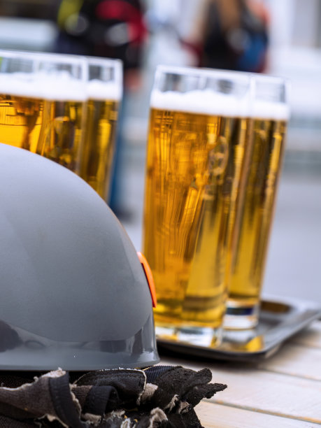 几杯啤酒放在桌子上，戴着登山装备，手套头盔，德国楚格斯皮策图片下载