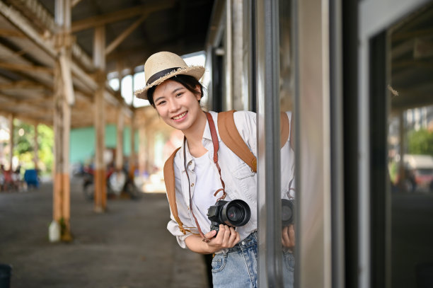 一个美丽的亚洲女游客在火车的梯子上，到达她的目的地站。图片下载