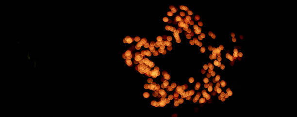 孤立的黑色背景模糊的散景与温暖的金色灯光在一个星星的形状，烟花。与空间复制，覆盖您的设计。高质量照片图片下载