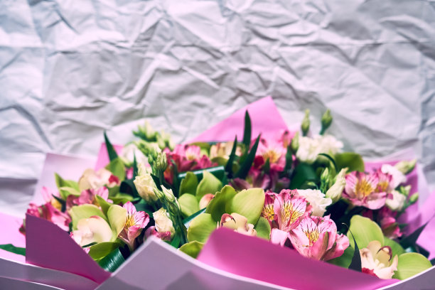 这张特写是一束五颜六色的兰花和木耳花的一部分，背景是包装上皱巴巴的纸。有空间复制。节日的概念。高质量照片图片下载
