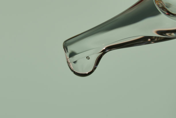近距离移液管，滴一滴天然有机面部精华液或恢复活力的有机精油。在时尚的浅绿色背景上。高质量照片图片下载