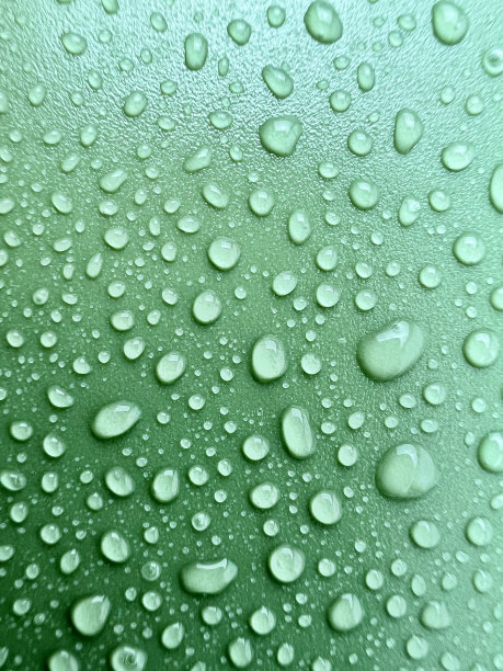 在绿色的背景上特写了很多水滴，反射图片下载