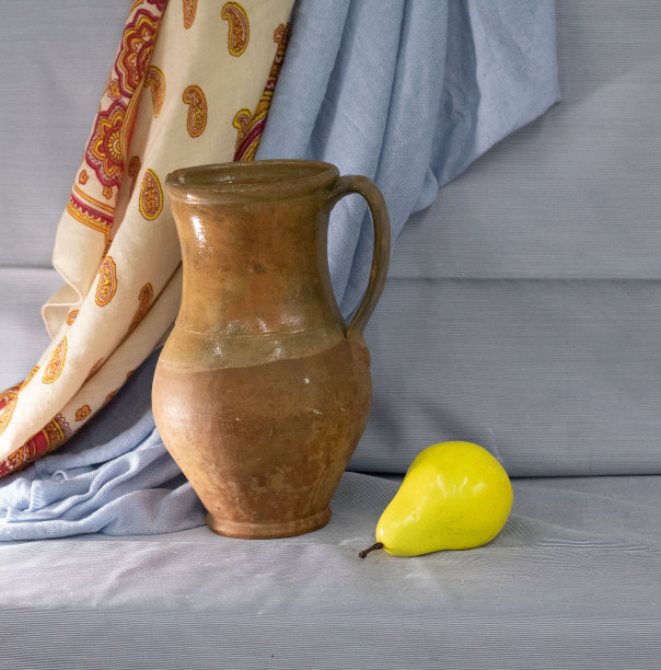 一个水罐和一个梨放在桌子上的照片图片下载