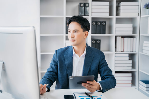 商人使用笔记本电脑进行笔记本支付，网上购物，全渠道，坐在办公桌前。图片下载