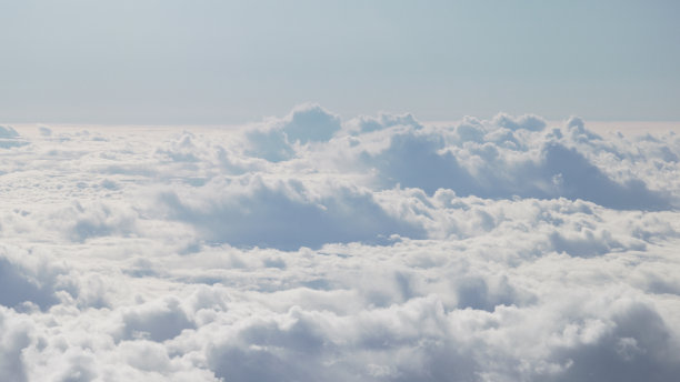 白天在云层上飞行的飞机的航拍照片图片下载