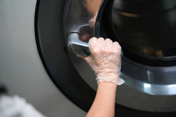 戴着防护手套的妇女手持工业洗衣机的大把手图片下载