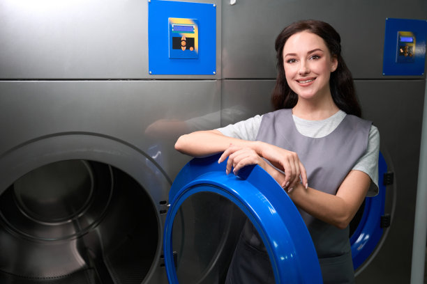 站在专业洗衣机或烘干机旁的妇女图片下载