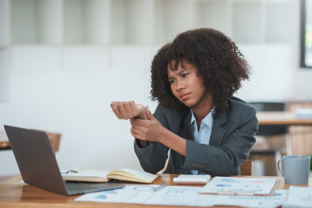 一位女商人因为使用笔记本电脑手腕疼痛，手腕疼痛。图片下载