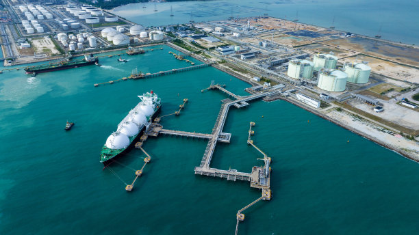 LNG(液化天然气)油轮锚定在天然气终端的储气罐中进行储存。石油、原油、天然气运输船。油船湾液化石油气、石油化工或甲烷货轮进出口运输及物流图片下载
