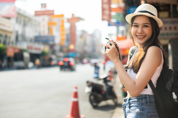 年轻的成年亚洲吃货女背包旅行者在唐人街街头小吃吃亚洲甜点。旅行女孩们正在享受曼谷美丽的地方，图片下载