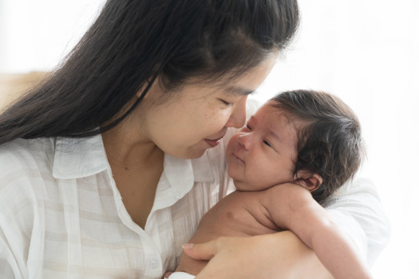 刚出生的婴儿在母亲的怀抱中睡觉。亚洲母亲用仁慈的双手照顾她的新生儿。家庭、爱情、幸福、新生活理念图片下载