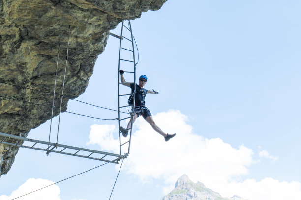 低角度看，人在Ferrata大街上爬梯子，成功的概念图片下载
