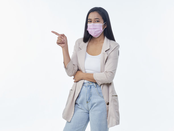 戴着防护面具的女人指着白色背景上的东西图片下载