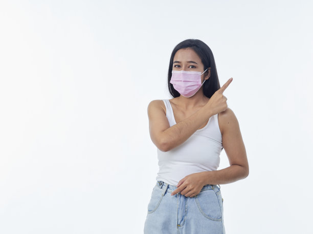 戴着防护面具的女人指着白色背景上的东西图片下载