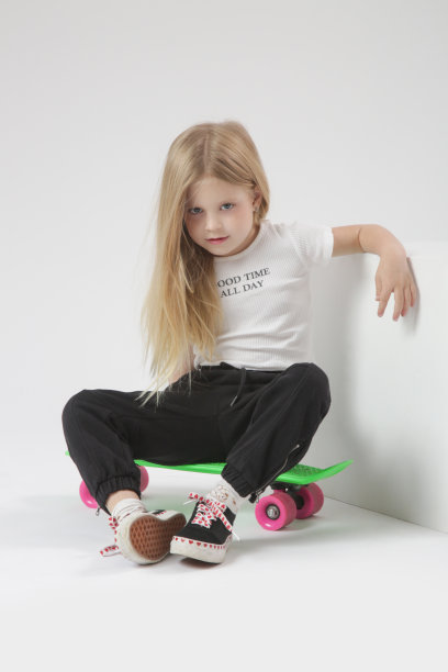 漂亮的金发小女孩的工作室肖像与滑板图片下载