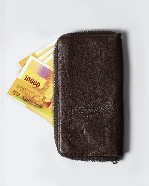 钱包里有1万张科摩罗法郎。科摩罗货币从一个棕色皮包里冒出来图片下载