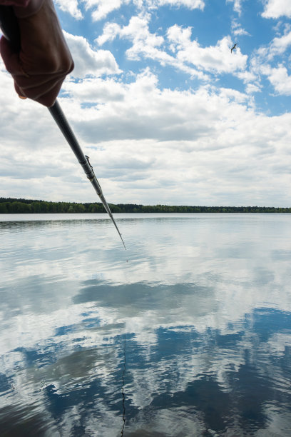 手里拿着钓竿在湖上钓鱼图片下载