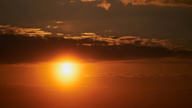夕阳把天空染成金色，在大地上投下长长的影子。图片下载