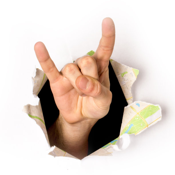 一只手从纸洞里伸出来的特写，一个摇滚标志，孤立的图片下载