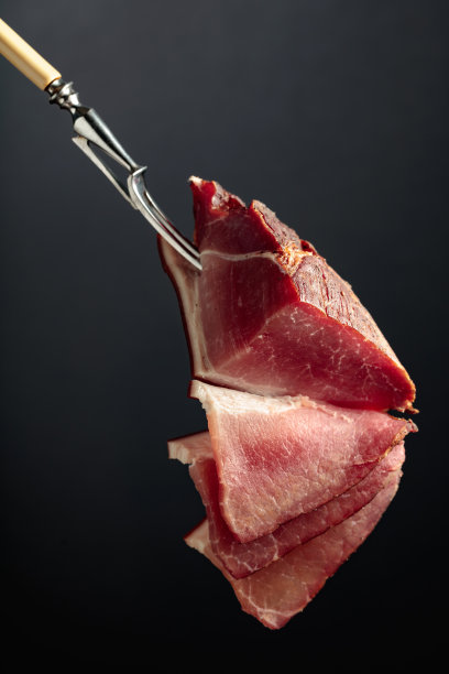 用叉子夹干猪肉片。图片下载