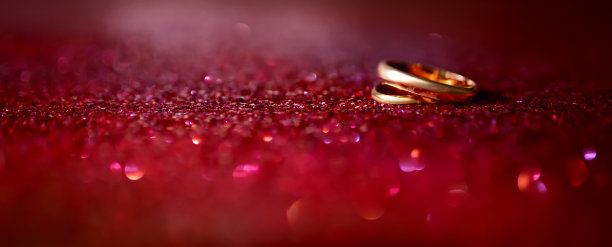 闪闪发光的红色背景上的结婚戒指图片下载