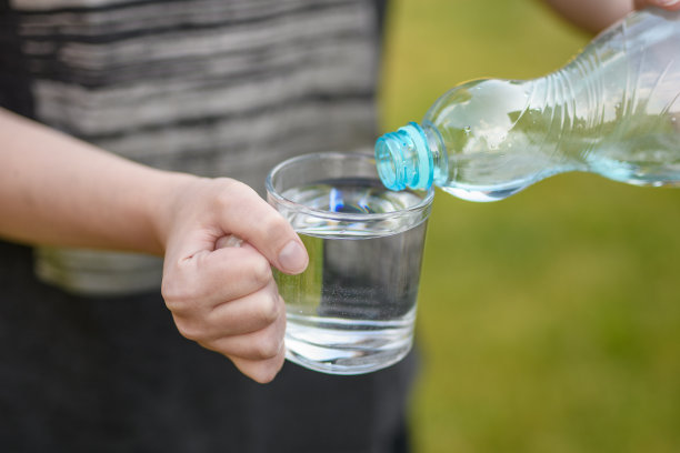 清澈的泉水倒进透明的玻璃杯里图片下载