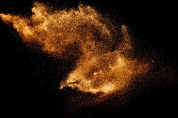 干河沙爆炸。棕色的沙子溅在黑色的背景。黄沙飞舞在空中。图片下载