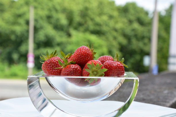 一个多汁的浆果草莓在一个透明的玻璃装饰板上模糊的背景的特写图片下载