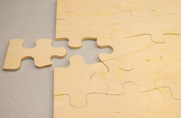 照片拼图散落在木板地板上的牛皮纸上。图片下载