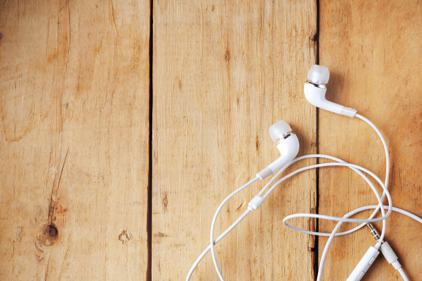 木质背景上的白色耳机图片下载
