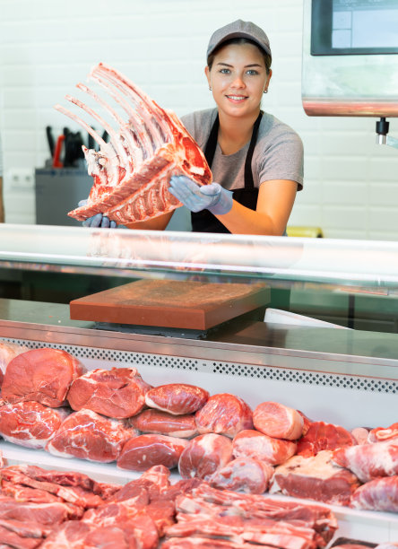 肉店女售货员拿着一块生牛肋排准备做战斧式牛排图片下载