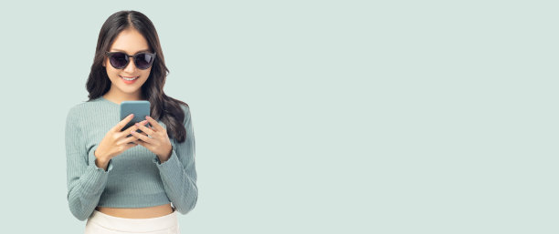 快乐和兴奋的年轻女子用手机站在孤立的绿色背景和复制空间年轻女孩用智能手机购物，网上聊天和发短信，她得到了惊喜图片下载